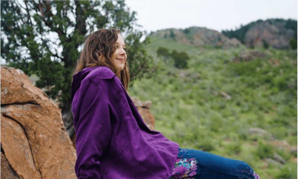 Alex sitting on rocks smiling